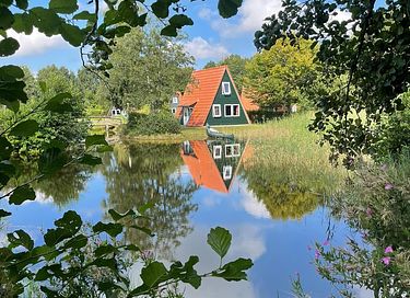 Knus huisje aan een visvijver in het groen