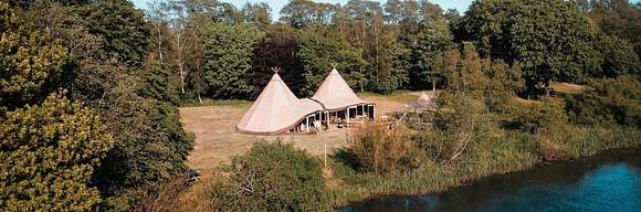 Tente tipi de luxe dans les bois au bord de l'eau