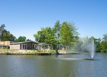Chalet spacieux au bord de l'eau dans un parc