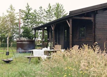Holzhütte mit Whirlpool im Grünen
