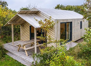 Wooden tiny house in the dunes