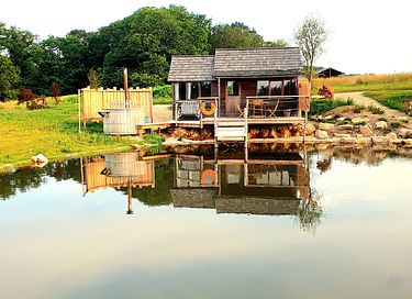 Tiny house aan het water met privé hottub